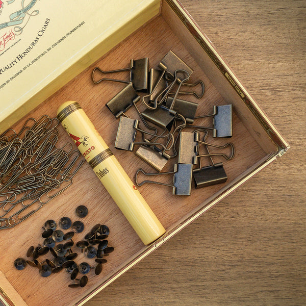 boho photo styling of open cigar box with antiqued brass thumbtacks paper clips and binder clips