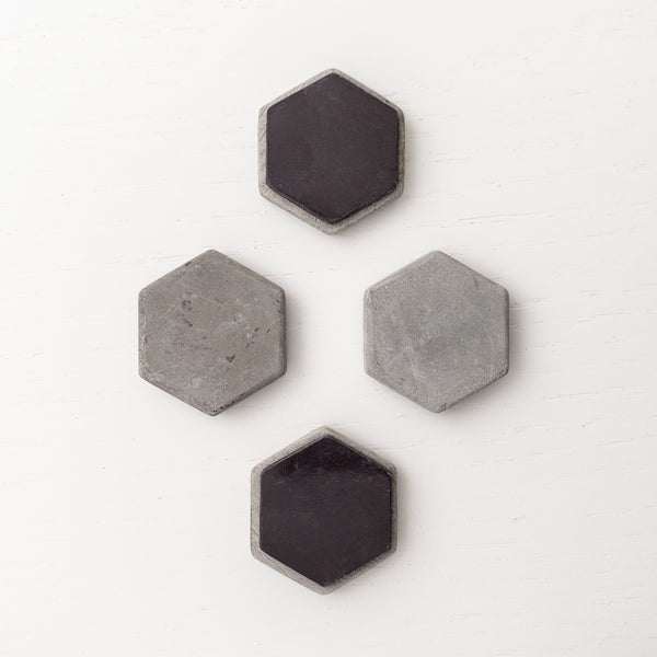 4 hexagon shaped concrete magnets arranged in a honeycomb pattern with two flipped over showing large hexagon shaped vinyl magnet on back